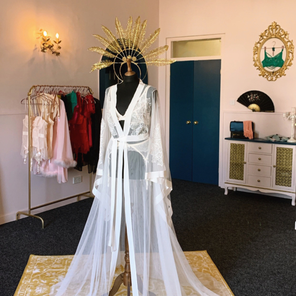 Bridal robe in showroom, wedding robe, honeymoon lingerie, bridal lingerie, showroom, clothing rails, gold feather headpiece.