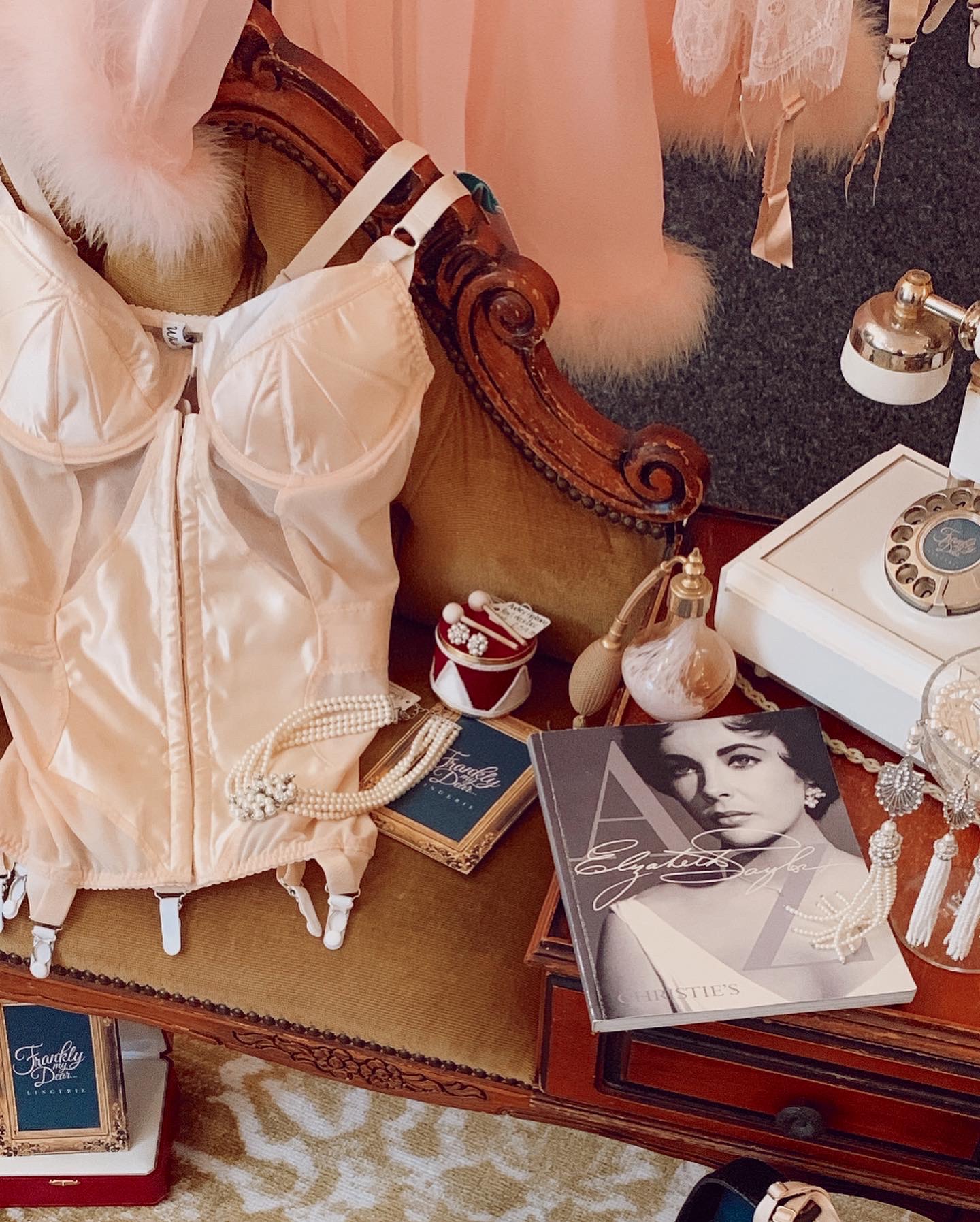 What Katie Did Peach corselette on vintage style telephone table with vintage telephone and Elizabeth Taylor book